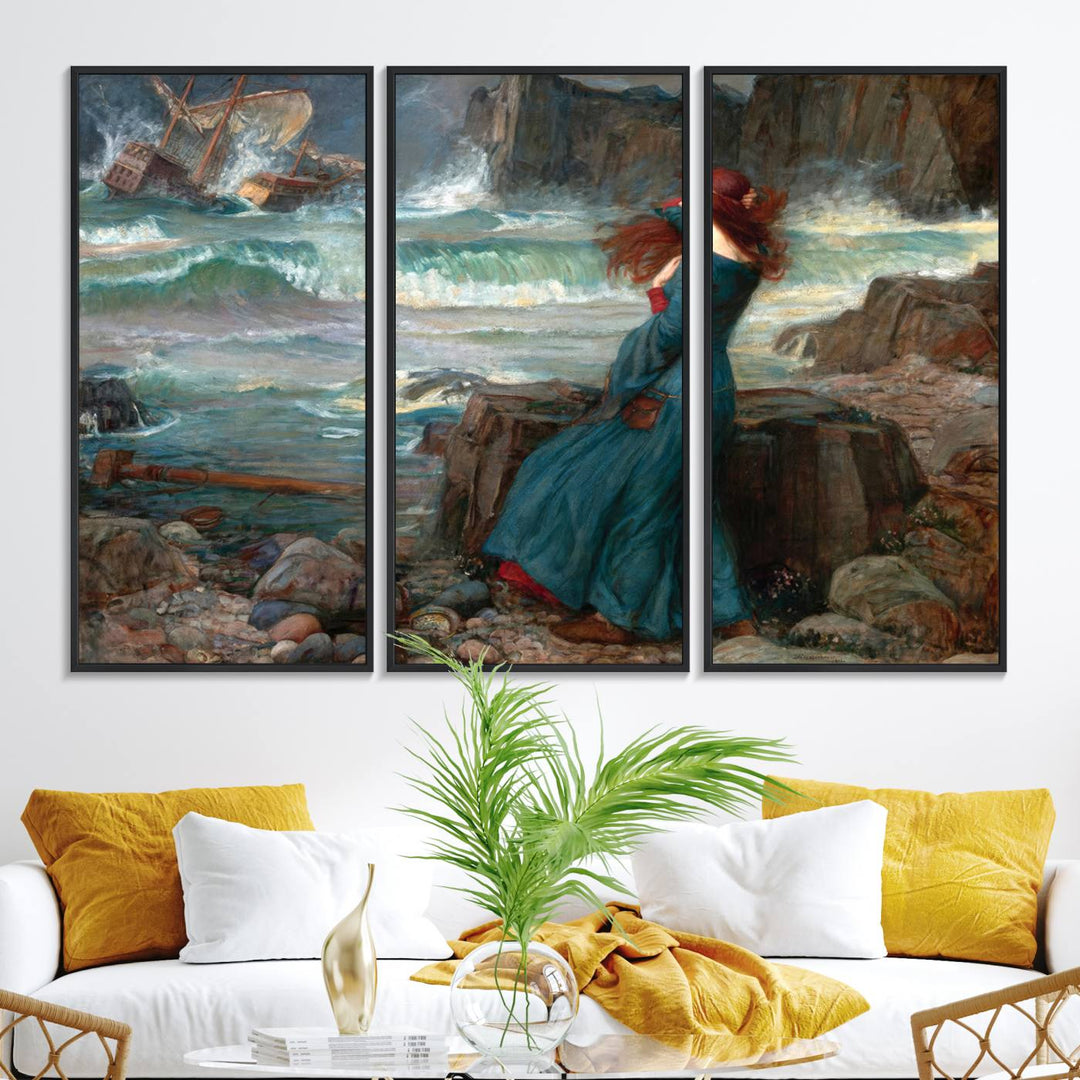 The Miranda by the Shore Wall Art Canvas Print depicts a woman in a blue dress standing by the sea, watching a shipwreck.