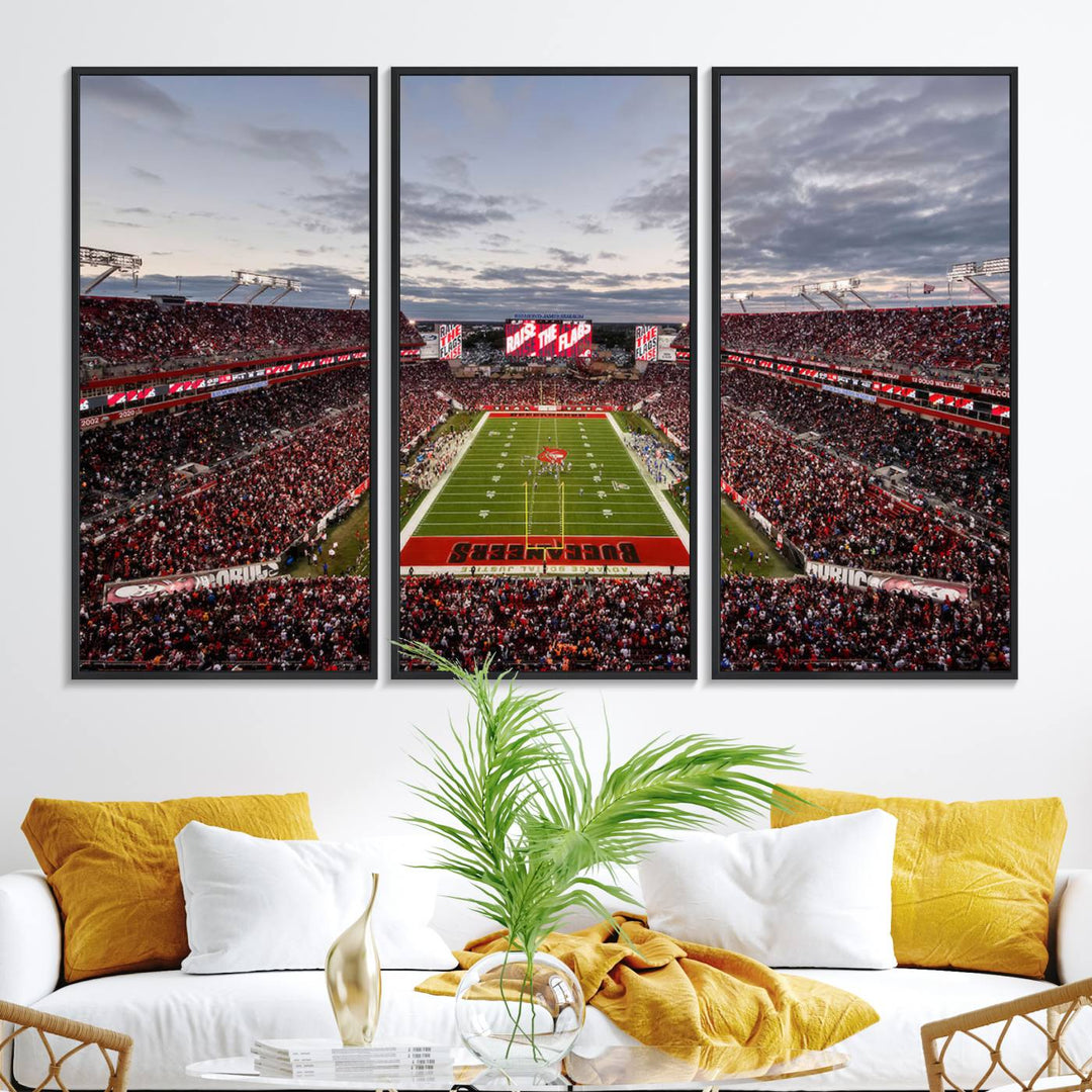 The wall art captures a stunning scene of Raymond James Stadium bathed in the warm hues of sunset. The sky, filled with clouds, provides a dramatic contrast to the vibrant lighting on the field, encapsulating the dynamic energy of a football game.