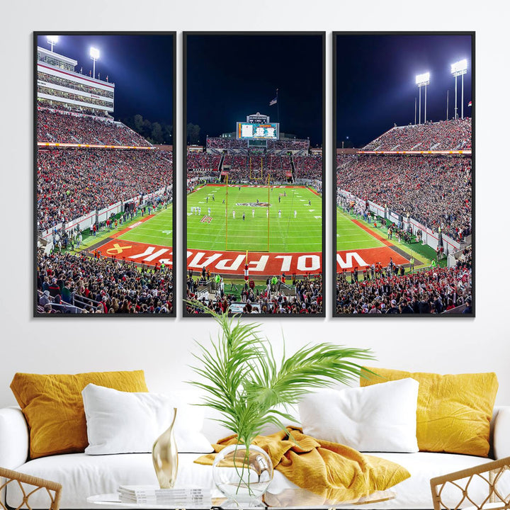 A NC State Wolfpack Football Team print of Carter-Finley Stadium at night features WOLFPACK illuminated brightly in the end zone grass.