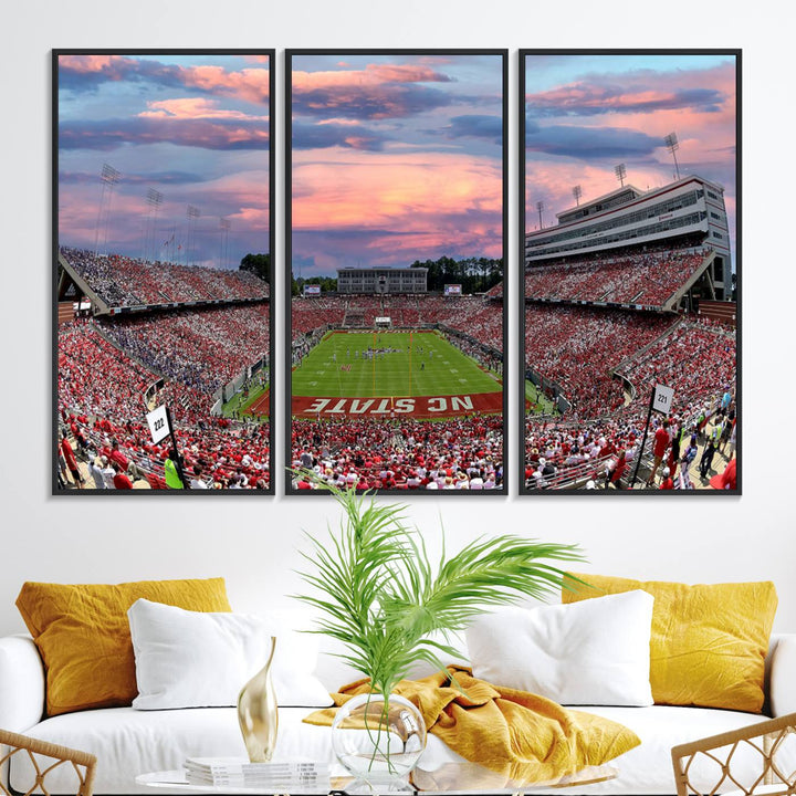 The wall art captures an NC State Wolfpack game under a vibrant sunset on triple canvas.