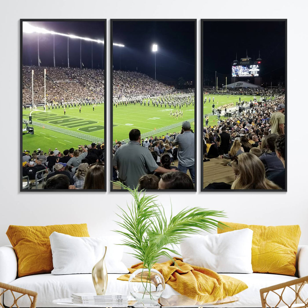 A painting depicting the Purdue Boilermakers football game at Ross-Ade Stadium is illuminated under gallery-quality lights.