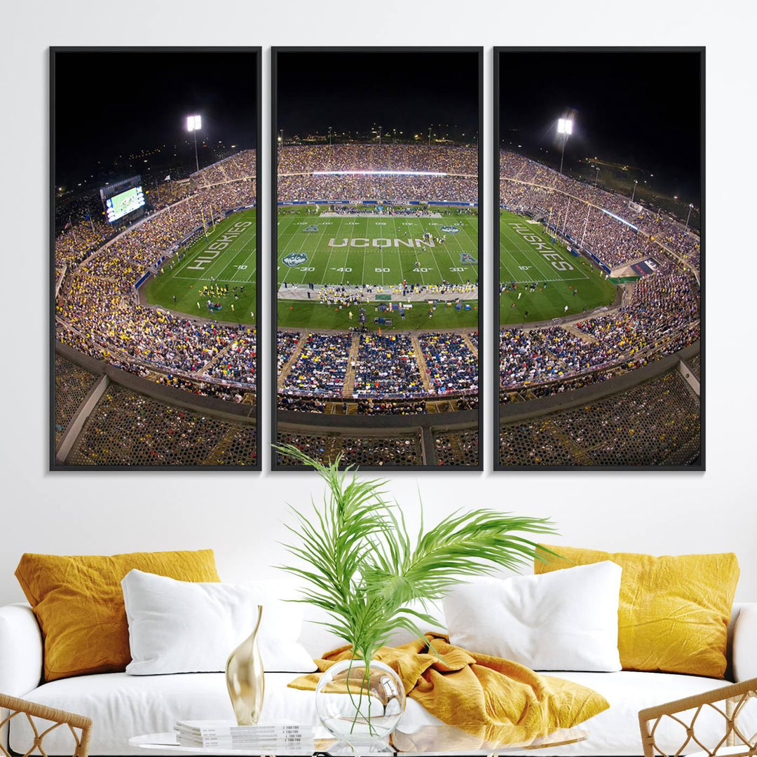 A large football stadium at night, featuring the UCONN Huskies, is depicted on the East Hartford Pratt & Whitney Stadium Wall Art Canvas Print.