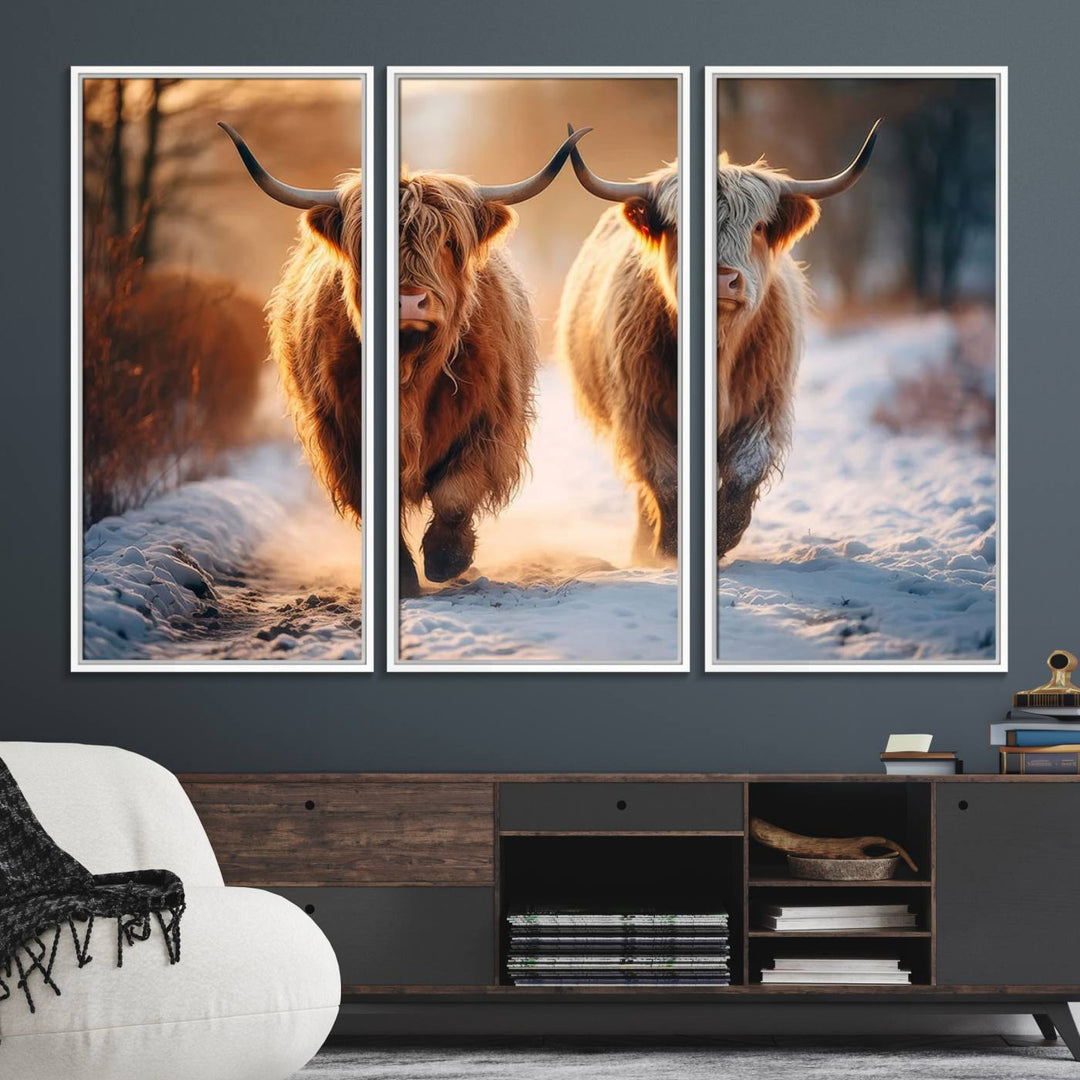 The wall art is a Scottish Highland Cow Horn canvas print featuring cows on a snowy path bathed in warm sunlight, serving as a rustic decor piece.