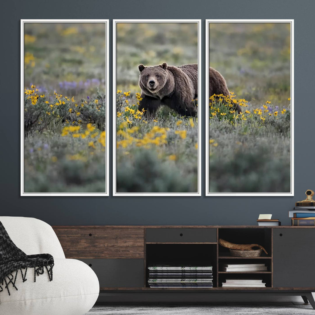 The "Grizzly 399 in Wild Flowers Wall Art Canvas Print" features a grizzly bear strolling through a field of yellow and purple flowers, beautifully showcased as a triptych. This handcrafted piece, proudly made in the USA, adds charm and sophistication to your space.