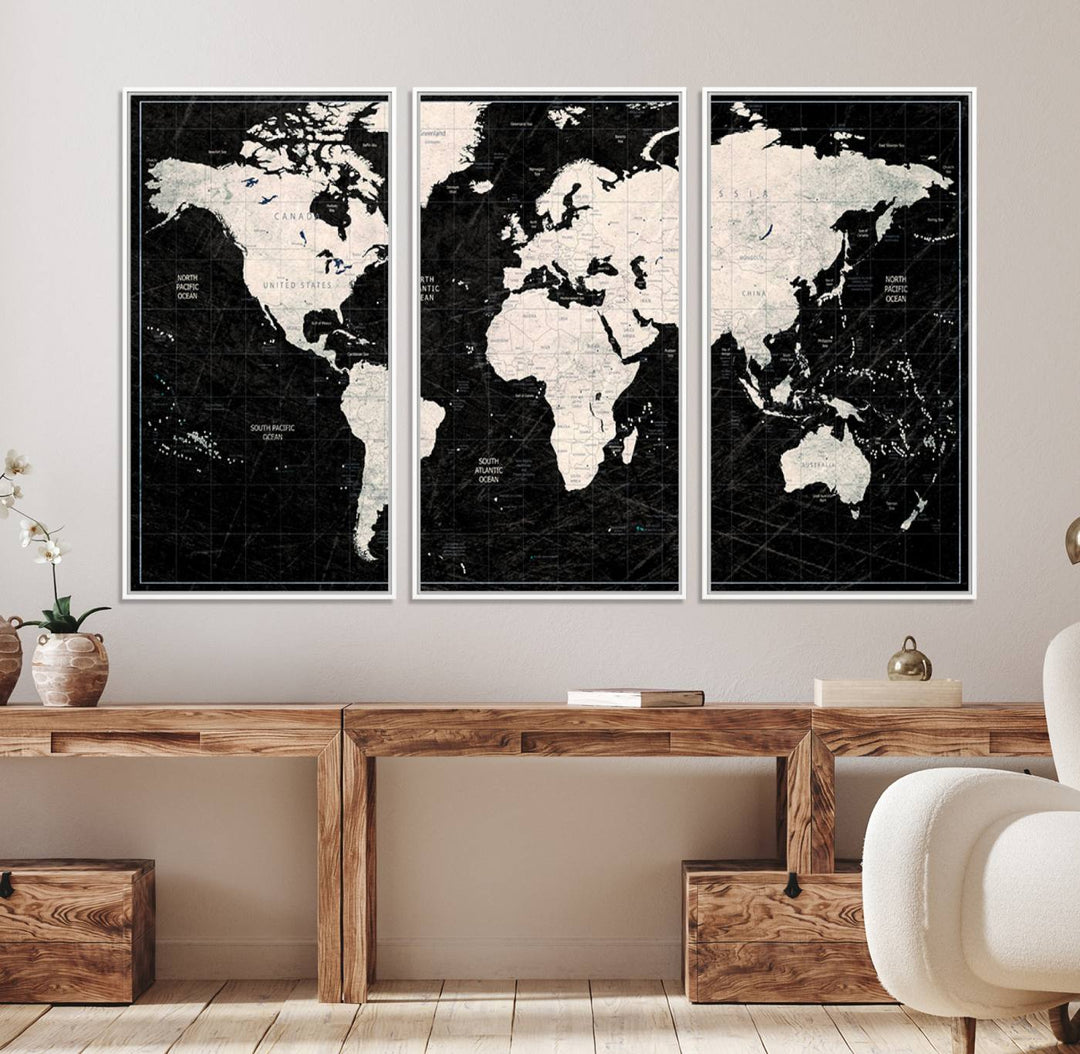 A bold global style framed black and white world map canvas print, presented in three panels, perfect for modern home or office decor.