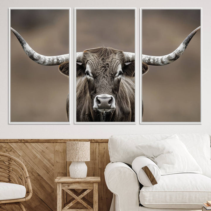 A close-up of a longhorn bull facing forward is featured in the Framed Texas Test-1, set against a blurred brown background.