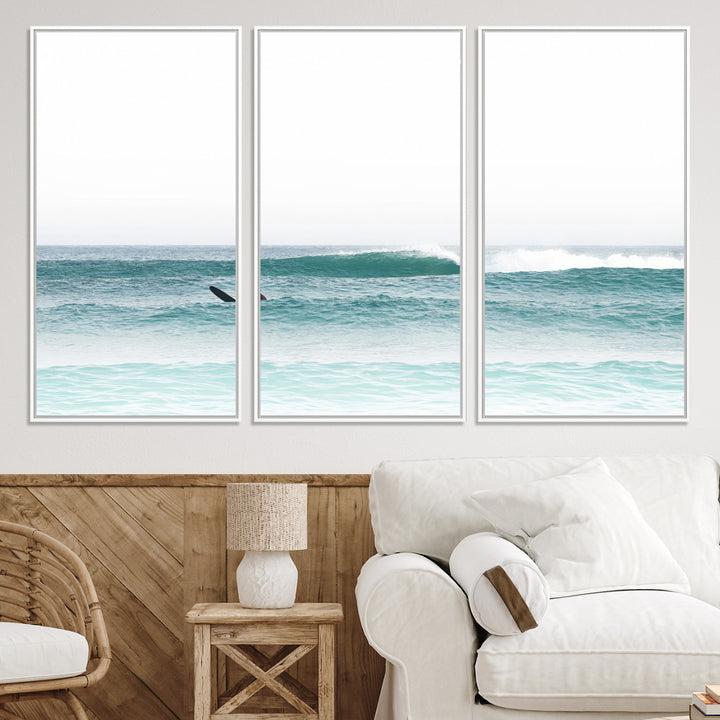 Minimalist photo of a lone surfer on calm aqua waves under bright sky, perfect for Scandinavian coastal or serene ocean-inspired home decor.
