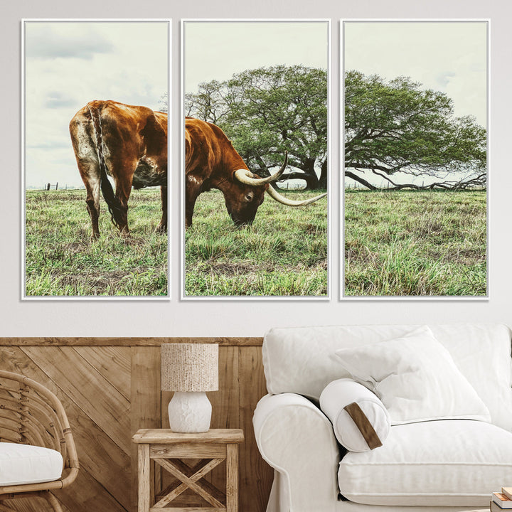 A Texas Longhorn grazing in a green pasture with a large tree in the background, evoking a rustic Western and farmhouse aesthetic.