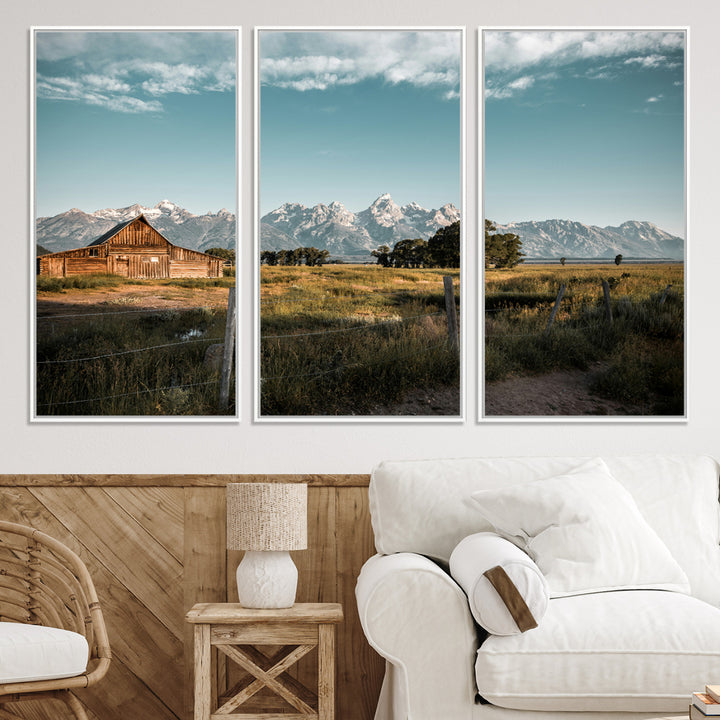 A rustic farmhouse with a wooden barn set against majestic mountain peaks under a soft blue sky, evoking peaceful countryside charm.