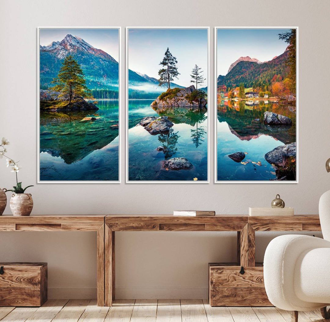 The 3-panel wall art showcases a serene mountain lake with rocky islands and trees, creating an ideal focal point for dining rooms or offices.