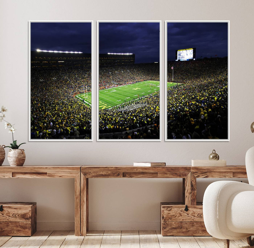 A painting of the packed Michigan Wolverines football stadium at night.