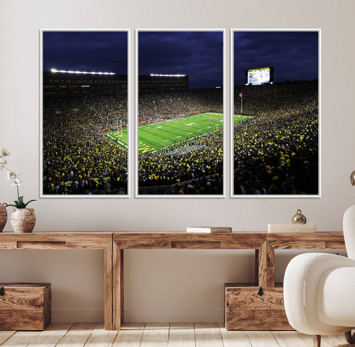 A painting of the packed Michigan Wolverines football stadium at night.