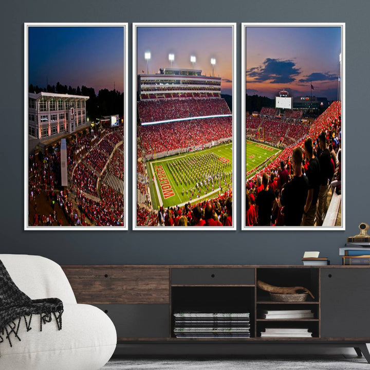 A print of a bustling Carter-Finley Stadium at dusk, featuring fans and a band, captures the essence of NC State Wolfpack football.