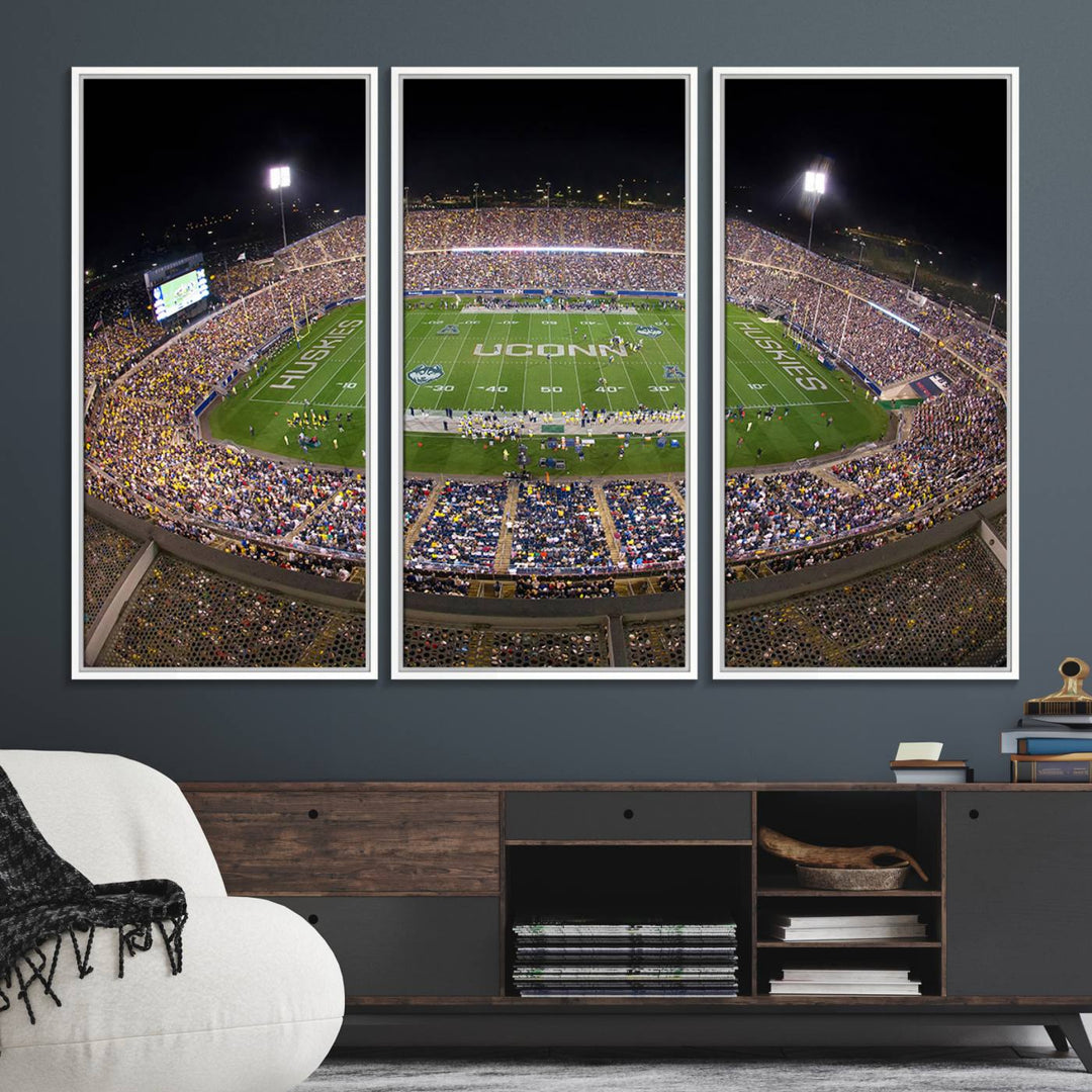 A large football stadium at night, featuring the UCONN Huskies, is depicted on the East Hartford Pratt & Whitney Stadium Wall Art Canvas Print.