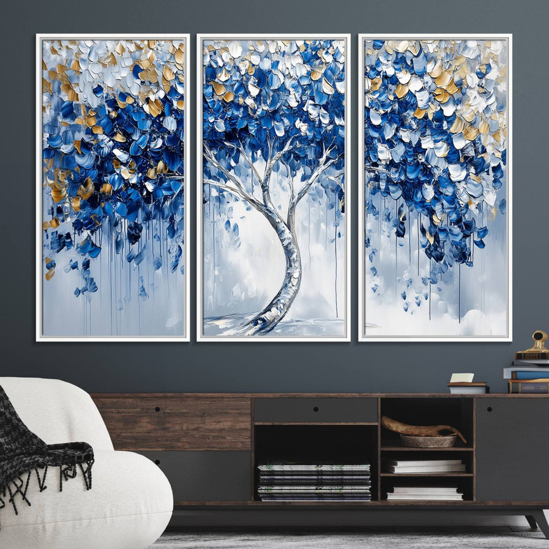 The Blue and Gold Abstract Tree Wall Art showcases a swirl trunk and features blue, silver, and gold leaves on a framed canvas print.