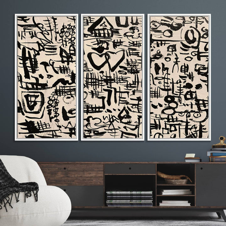 The Abstract Love and Chaos canvas is a museum-quality print featuring black symbols on a beige background, adorned with a heart and scribble design. It is framed to enhance its artistic appeal.