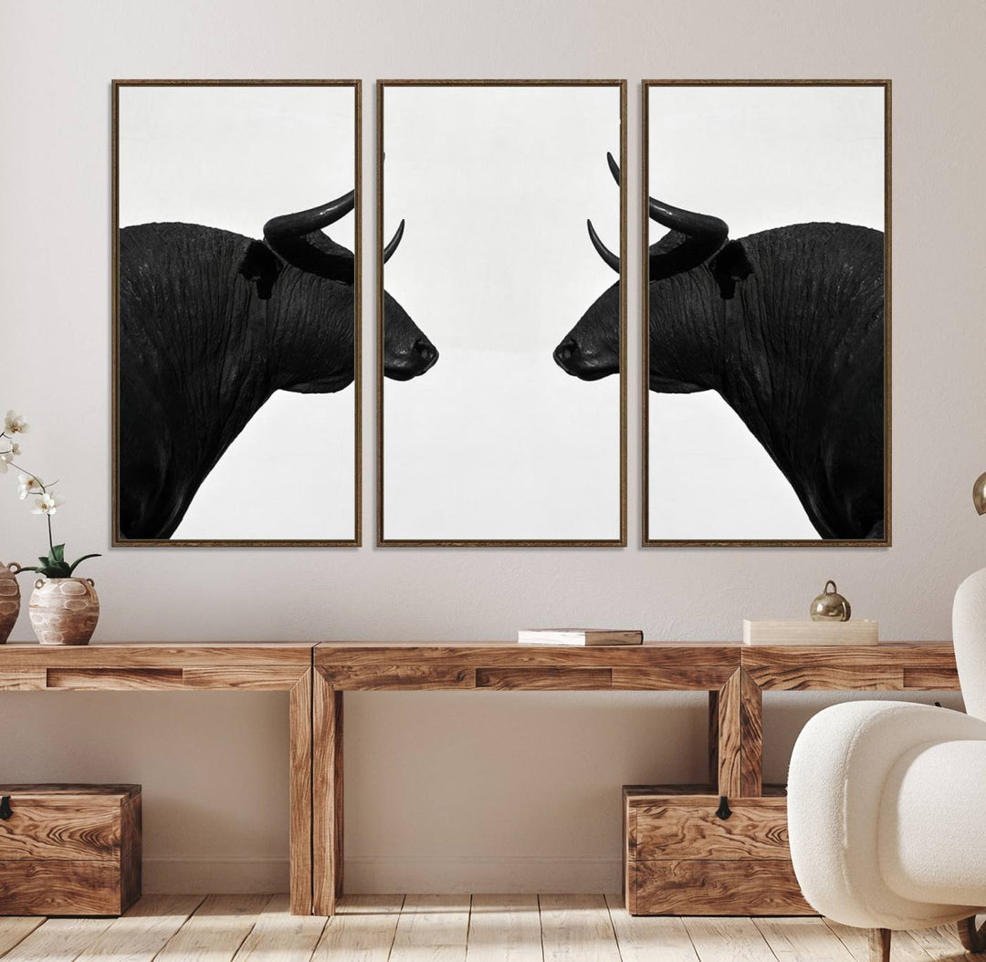 A framed canvas print featuring two black bull silhouettes, perfect for modern rustic decor.