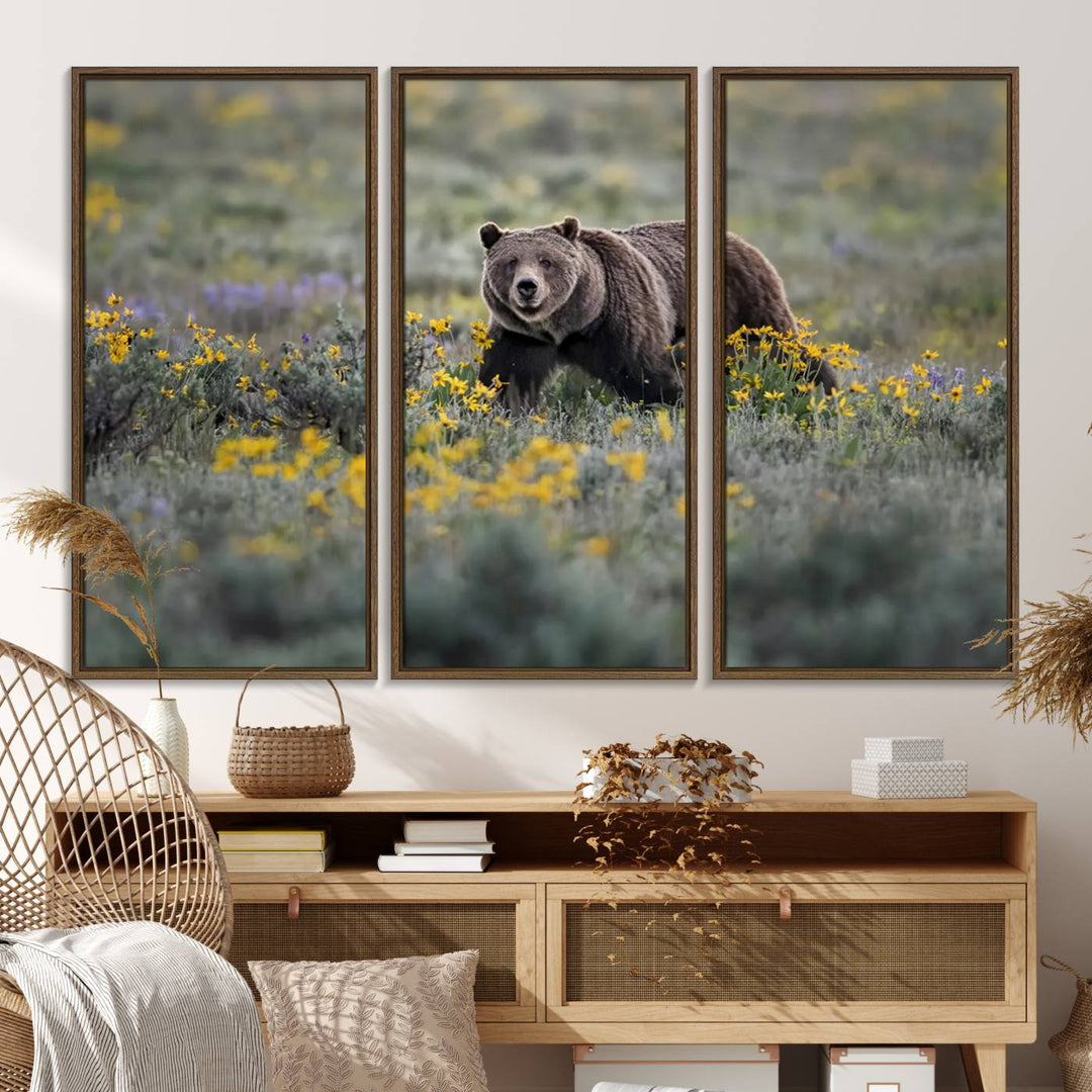 The "Grizzly 399 in Wild Flowers Wall Art Canvas Print" features a grizzly bear strolling through a field of yellow and purple flowers, beautifully showcased as a triptych. This handcrafted piece, proudly made in the USA, adds charm and sophistication to your space.