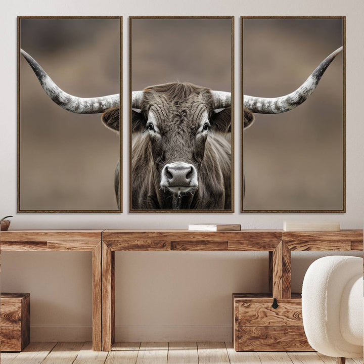 A close-up of a longhorn bull facing forward is featured in the Framed Texas Test-1, set against a blurred brown background.