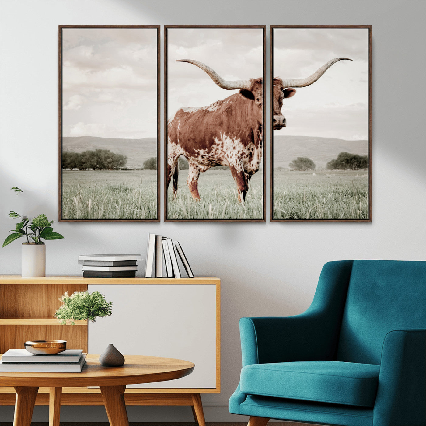 Canvas of a Texas longhorn standing in a grassy field with mountains in the background, ideal for rustic or country-style western wall decor.