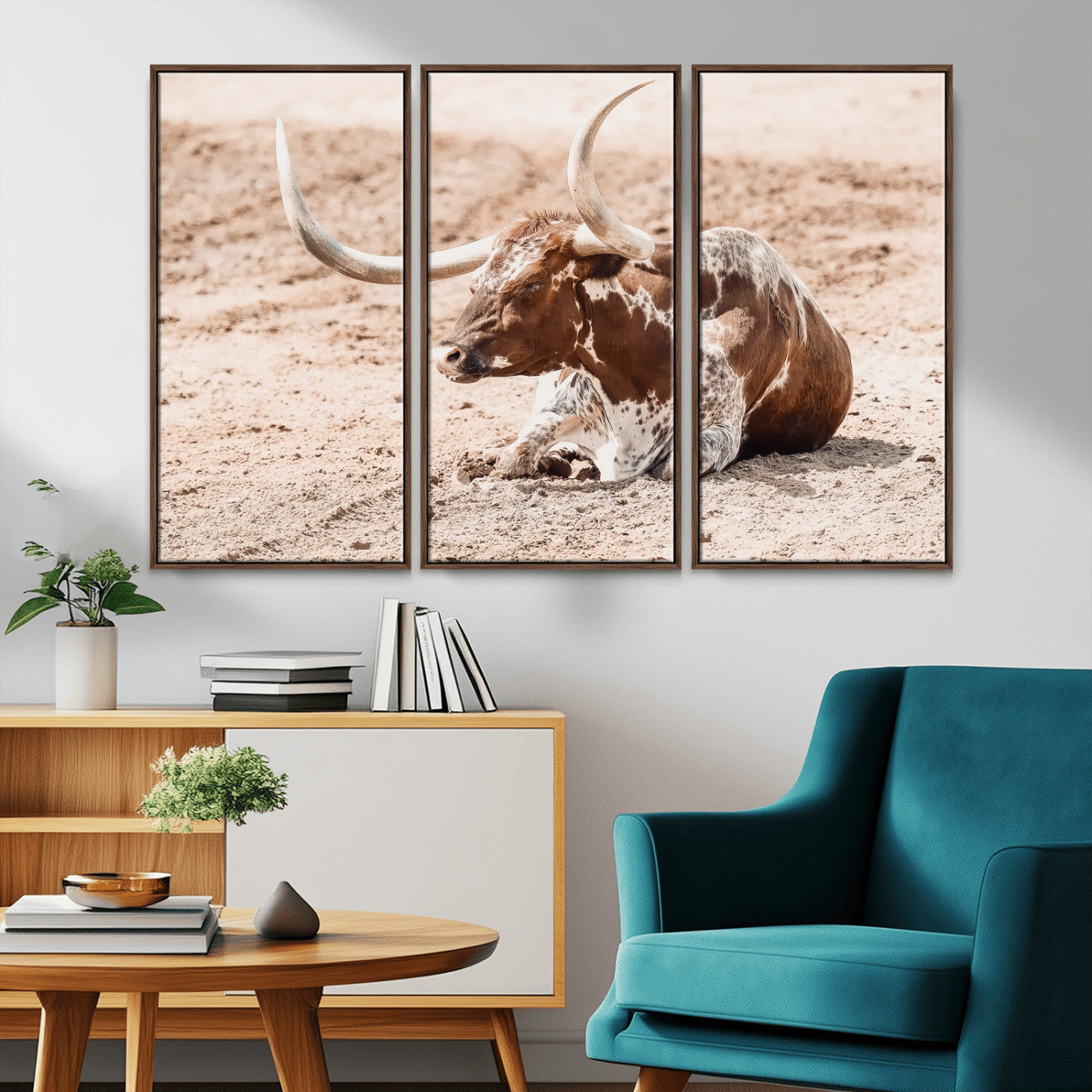 Texas Longhorn bull resting on dusty ground with warm tones, ideal for rustic western or farmhouse-themed wall decor.