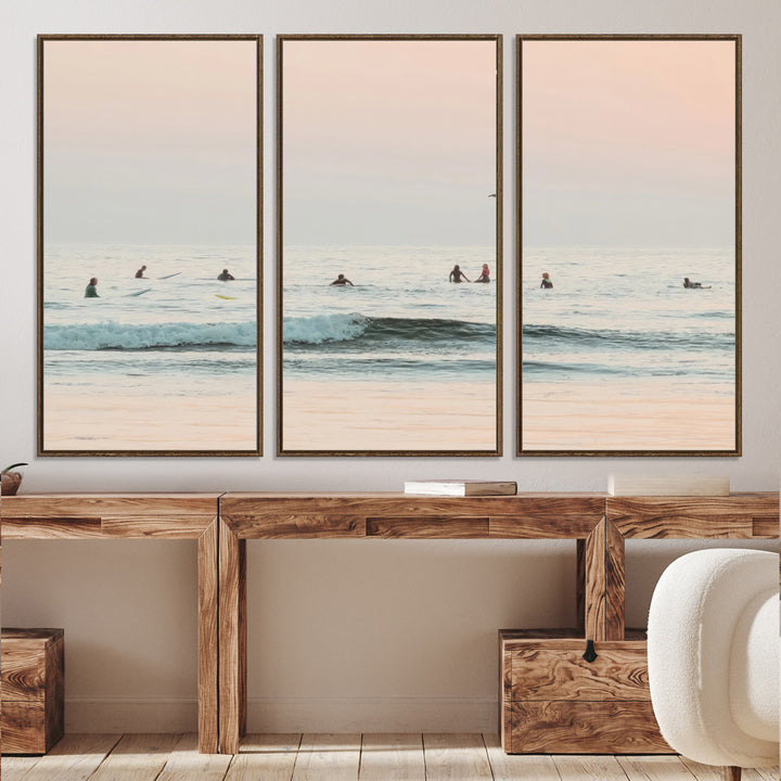 Dreamy photo of surfers waiting on soft pastel waves under a pink sunset sky, ideal for soft coastal minimalist or serene ocean-themed home decor.
