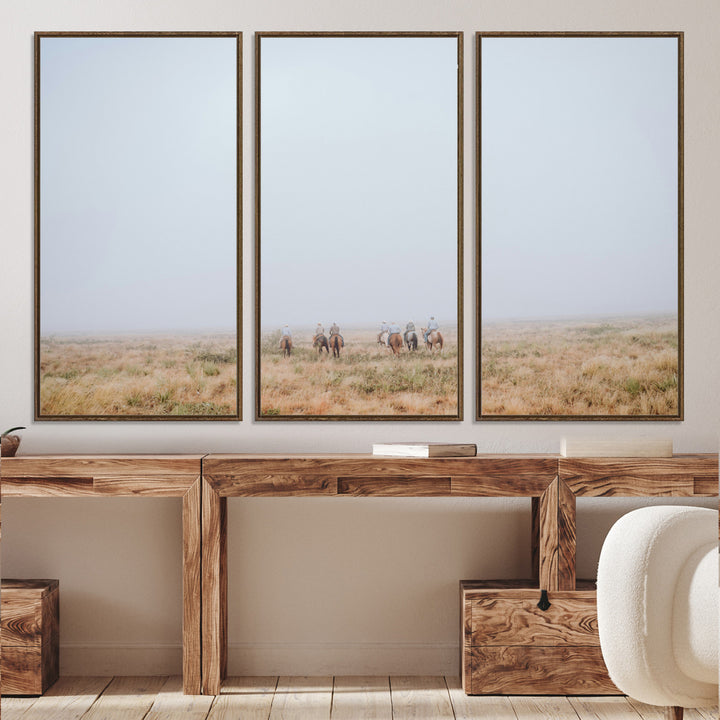 A group of horseback riders moving through a fog-shrouded field, evoking a calm Western scene with golden grasses and soft horizons.