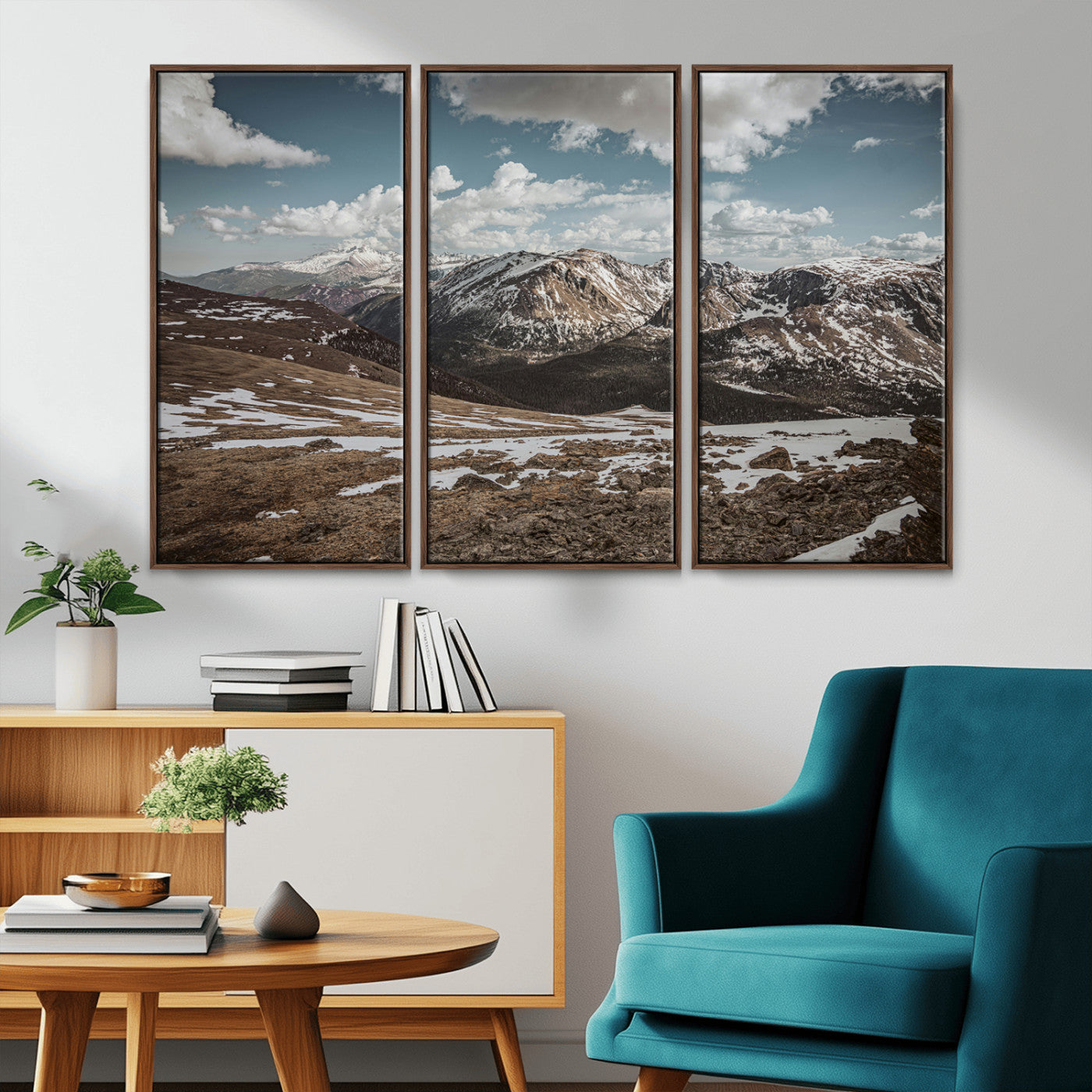 A breathtaking mountain landscape with rugged peaks, patches of snow, and dramatic clouds casting shadows over the vast alpine wilderness.