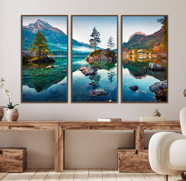 The 3-panel wall art showcases a serene mountain lake with rocky islands and trees, creating an ideal focal point for dining rooms or offices.