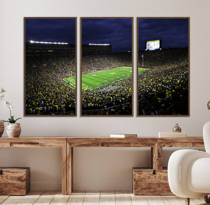 A painting of the packed Michigan Wolverines football stadium at night.