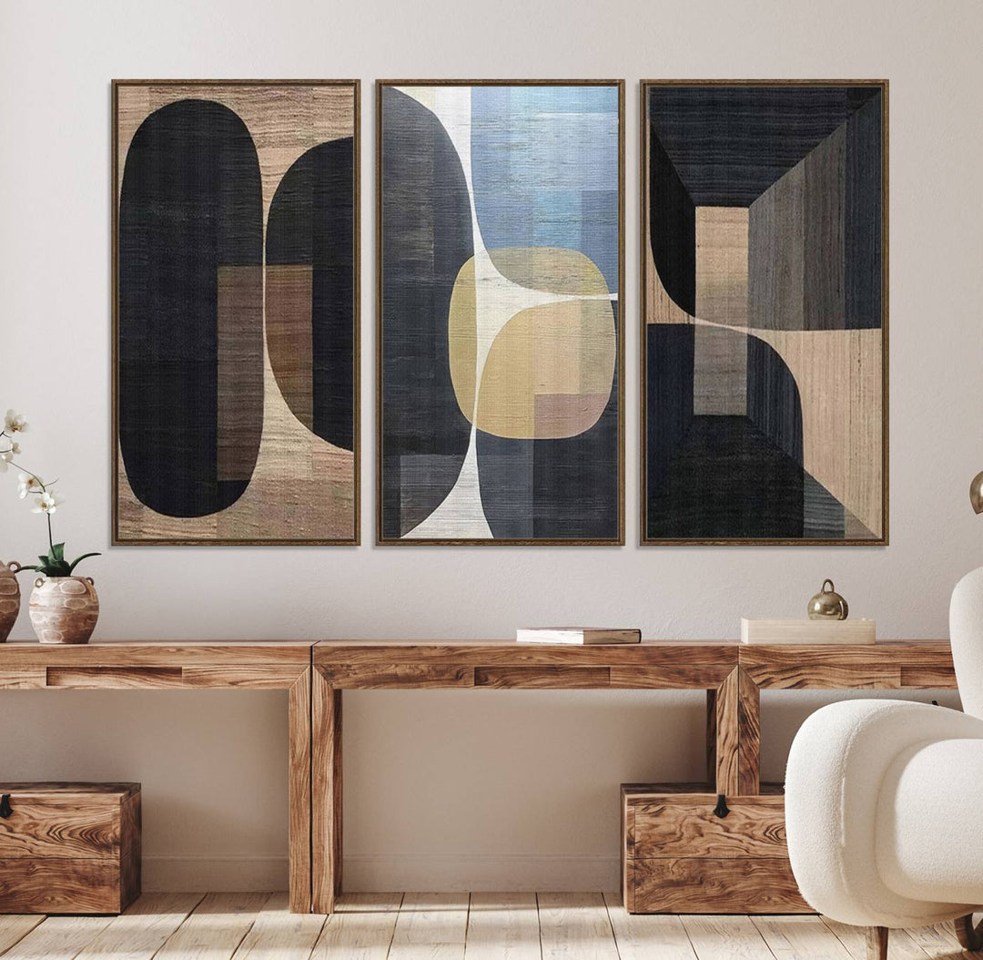 Abstract geometric wall art featuring black, gray, beige, and blue tones framed in a wooden border.