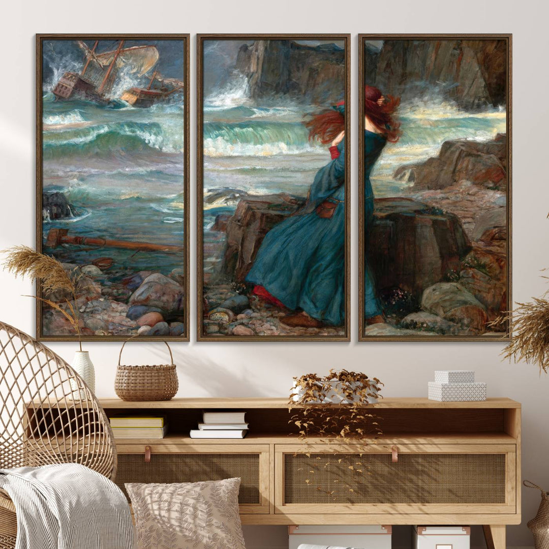 The Miranda by the Shore Wall Art Canvas Print depicts a woman in a blue dress standing by the sea, watching a shipwreck.