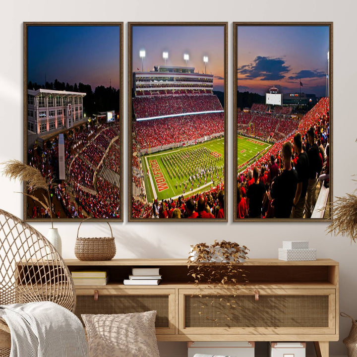 A print of a bustling Carter-Finley Stadium at dusk, featuring fans and a band, captures the essence of NC State Wolfpack football.