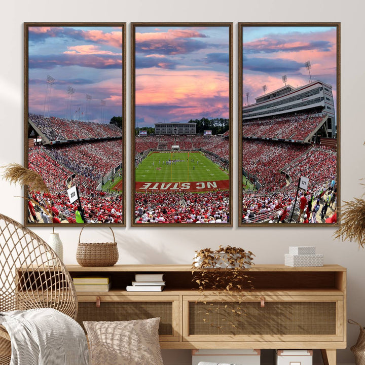 The wall art captures an NC State Wolfpack game under a vibrant sunset on triple canvas.