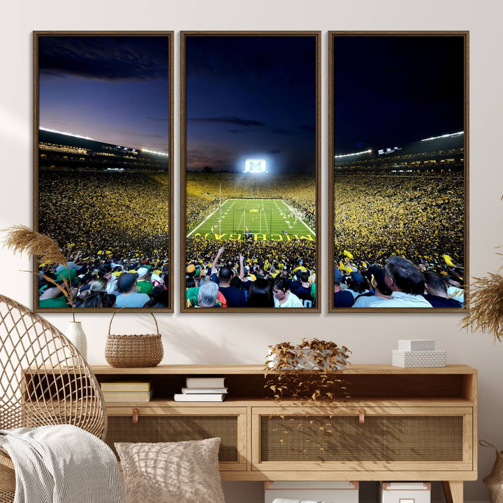 The wall art features a glowing M in this Michigan Wolverines Football Team Ann Arbor Stadium Canvas Print.