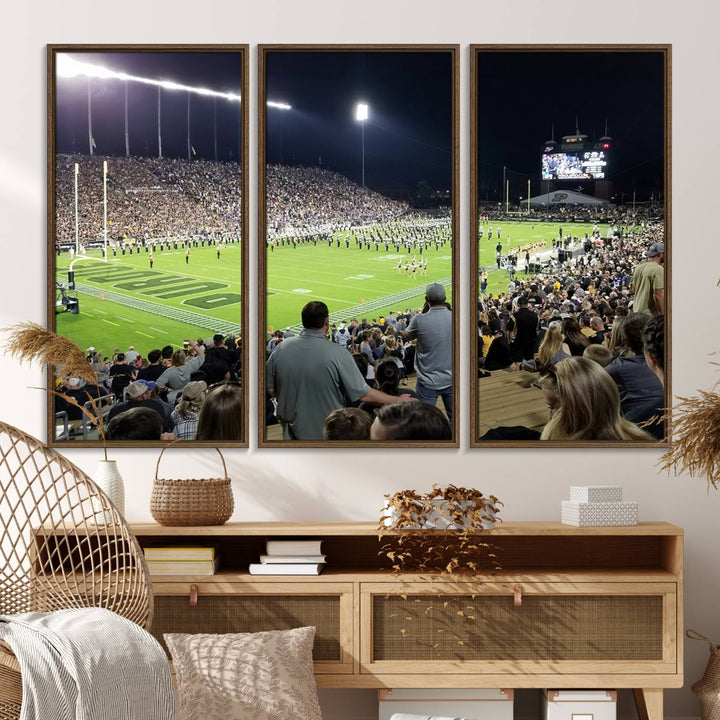 A painting depicting the Purdue Boilermakers football game at Ross-Ade Stadium is illuminated under gallery-quality lights.