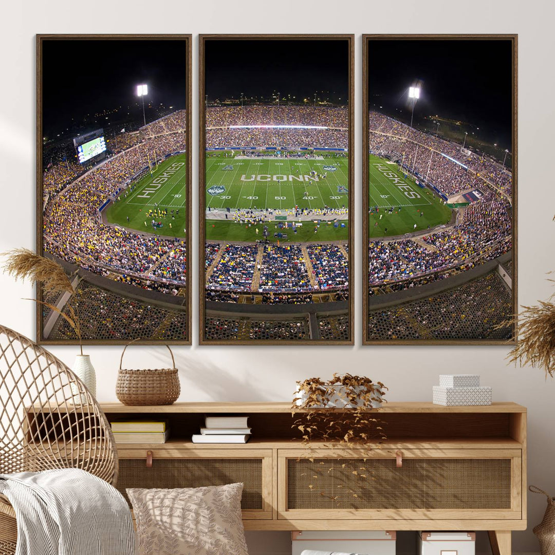 A large football stadium at night, featuring the UCONN Huskies, is depicted on the East Hartford Pratt & Whitney Stadium Wall Art Canvas Print.