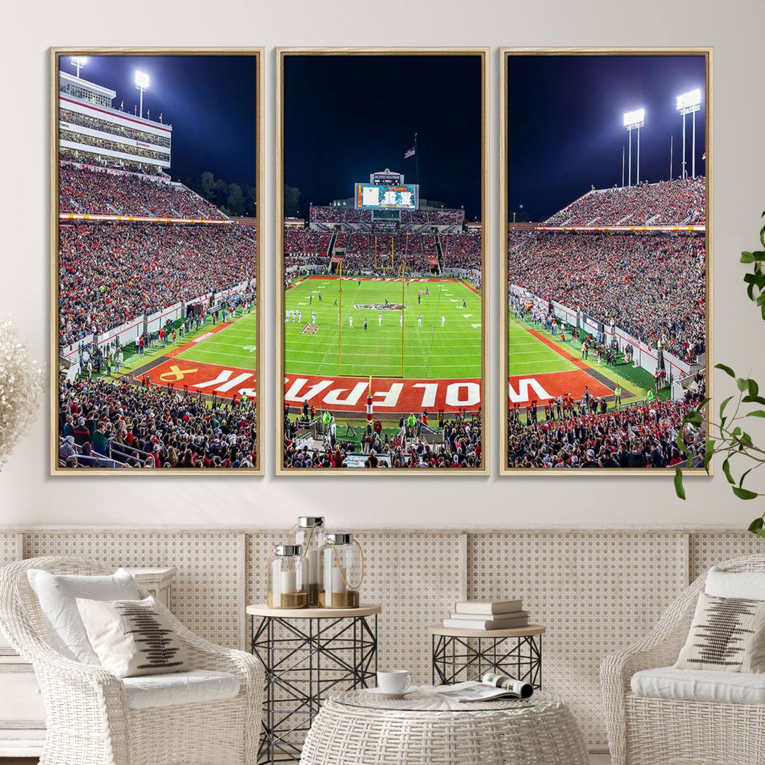 A NC State Wolfpack Football Team print of Carter-Finley Stadium at night features WOLFPACK illuminated brightly in the end zone grass.