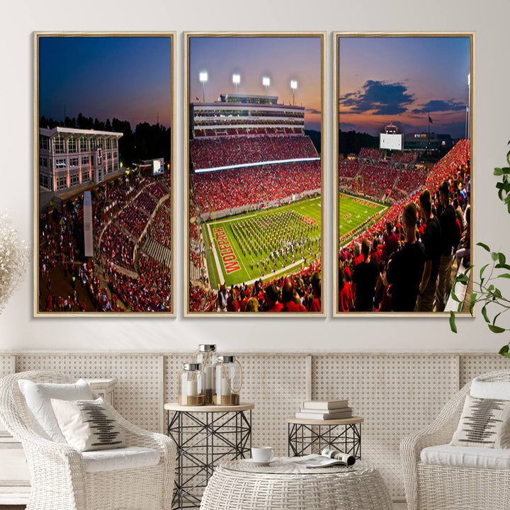 A print of a bustling Carter-Finley Stadium at dusk, featuring fans and a band, captures the essence of NC State Wolfpack football.