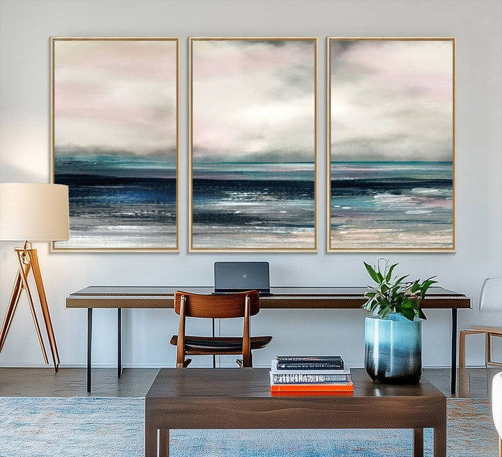 A contemporary abstract wall art canvas print in pastel pink, teal, and gray tones hangs on the wall.