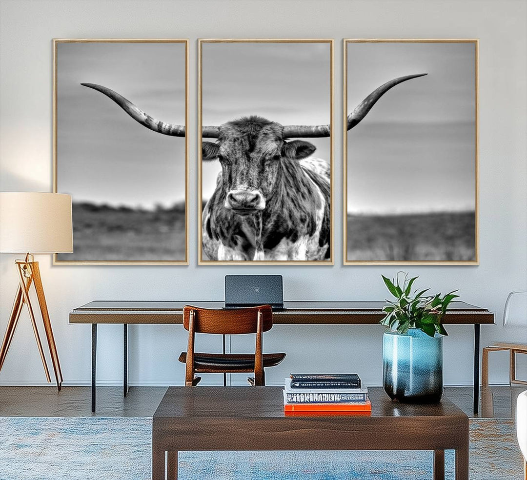 The Texas Longhorn Cow wall art, divided into three panels, is of gallery quality and displayed on a dark wall.