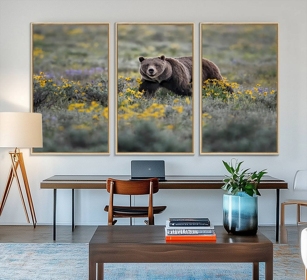 The "Grizzly 399 in Wild Flowers Wall Art Canvas Print" features a grizzly bear strolling through a field of yellow and purple flowers, beautifully showcased as a triptych. This handcrafted piece, proudly made in the USA, adds charm and sophistication to your space.