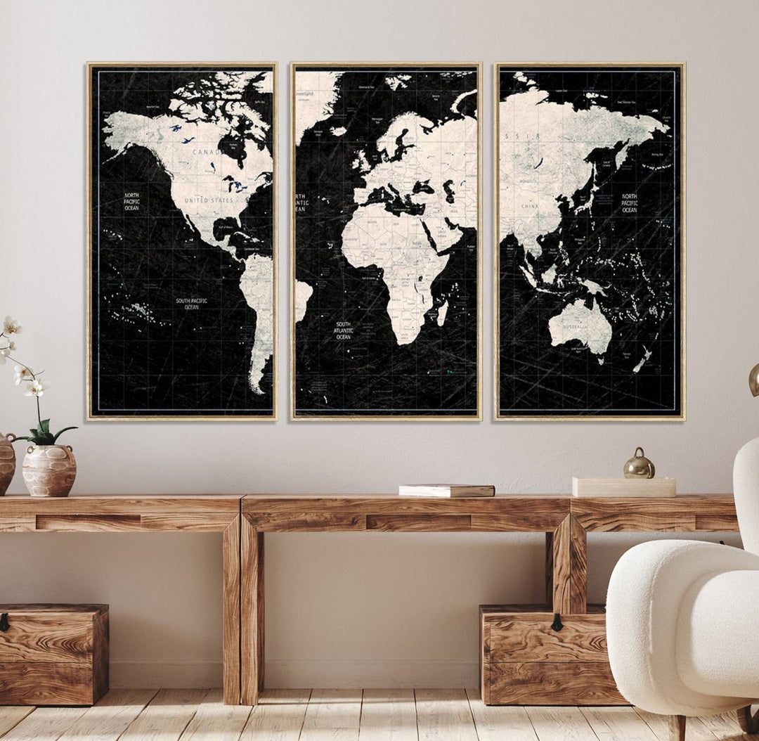 A bold global style framed black and white world map canvas print, presented in three panels, perfect for modern home or office decor.