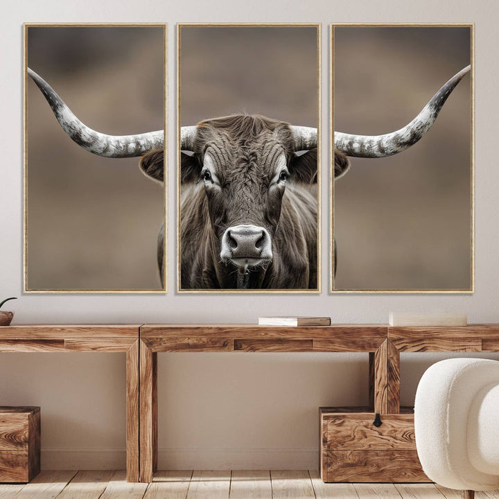 A close-up of a longhorn bull facing forward is featured in the Framed Texas Test-1, set against a blurred brown background.