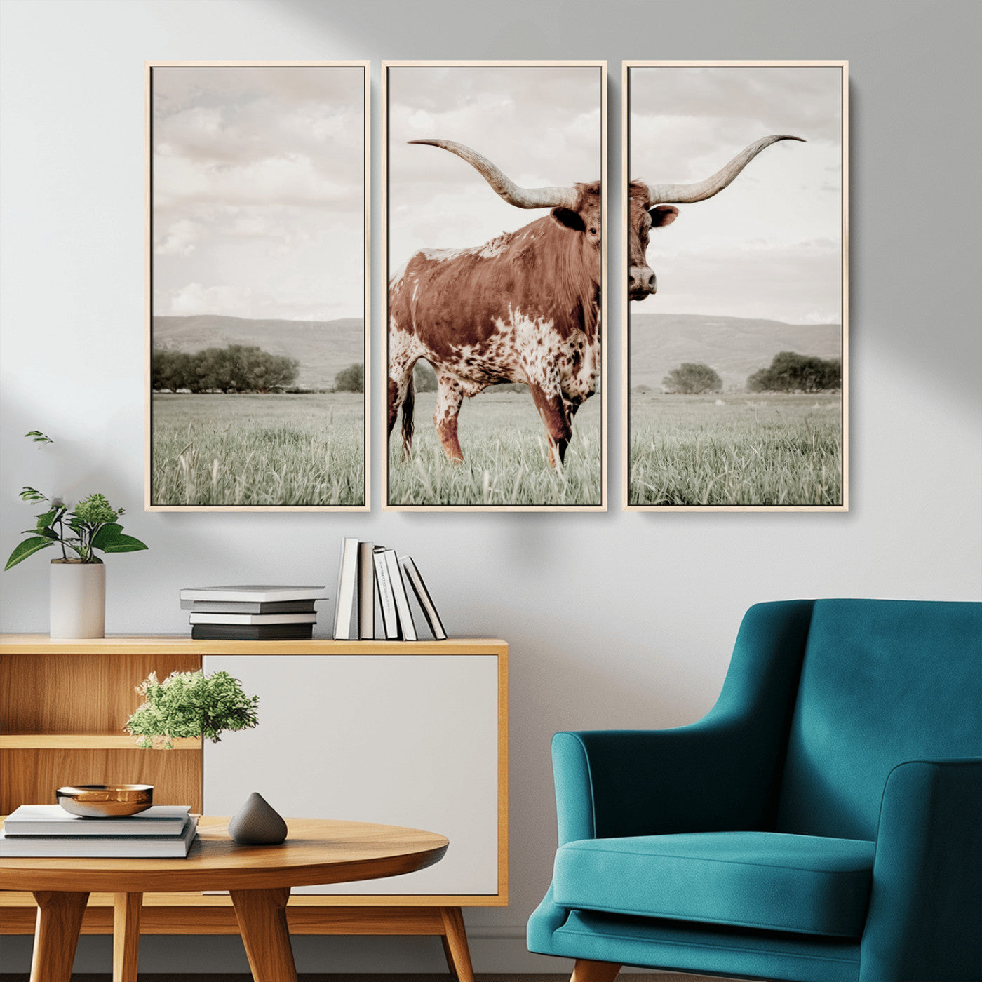 Canvas of a Texas longhorn standing in a grassy field with mountains in the background, ideal for rustic or country-style western wall decor.