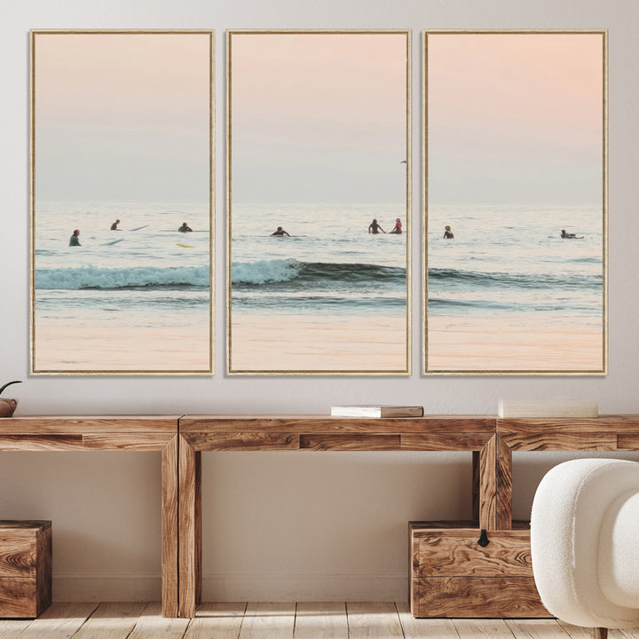 Dreamy photo of surfers waiting on soft pastel waves under a pink sunset sky, ideal for soft coastal minimalist or serene ocean-themed home decor.