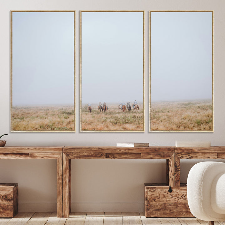 A group of horseback riders moving through a fog-shrouded field, evoking a calm Western scene with golden grasses and soft horizons.
