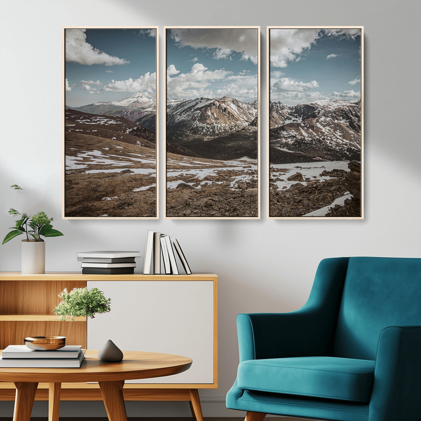 A breathtaking mountain landscape with rugged peaks, patches of snow, and dramatic clouds casting shadows over the vast alpine wilderness.