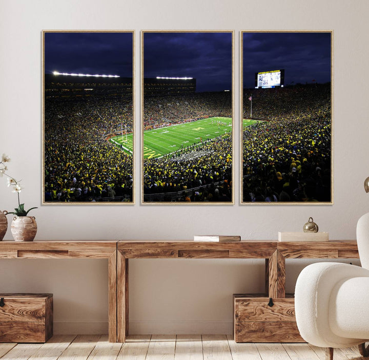 A painting of the packed Michigan Wolverines football stadium at night.