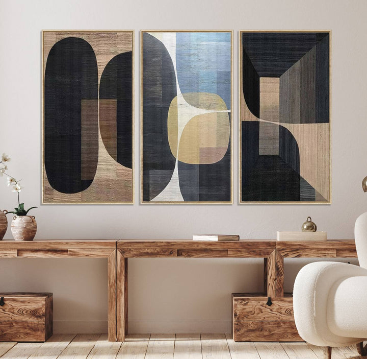 Abstract geometric wall art featuring black, gray, beige, and blue tones framed in a wooden border.